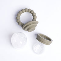 Beige baby teething ring with clear silicone disc on a white background